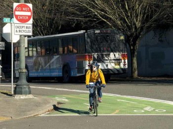 Um ciclista usa a ciclovia exclusiva pintada de verde no centro de Portland, nos EUA