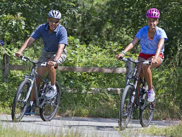Obama e sua filha, Malía, pedalam pelo Bosque Estadual Manuel F. Correllus - Foto: Jacquelyn Martin/AP