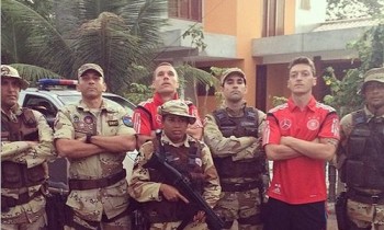 Policiais militares, portando armas e um fuzil, protegem o local de concentração da seleção alemã de futebol