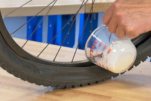 Instalação de líquido selante em um pneu parcialmente desmontado da roda - Foto: Park Tool
